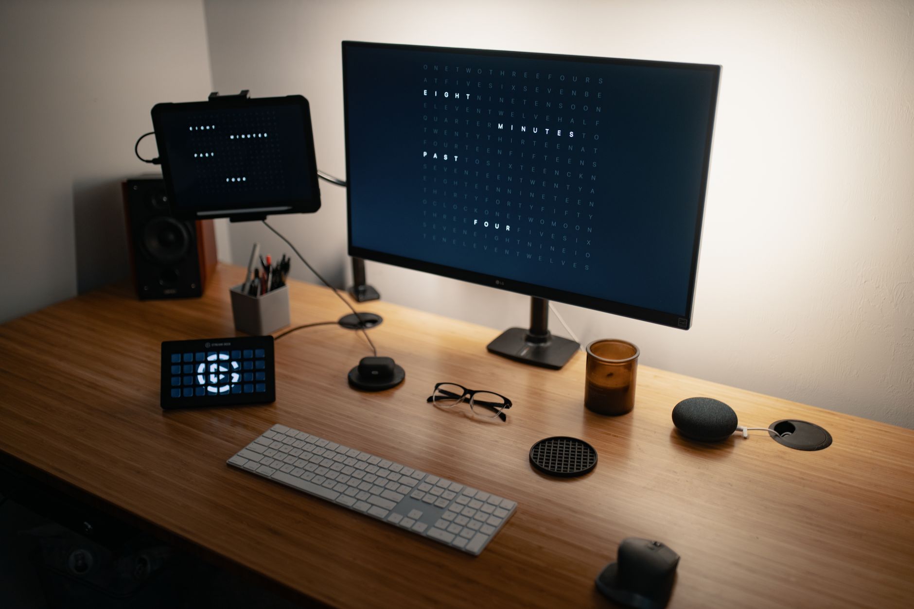 A tidy professional workstation with a large monitor on a wooden desk